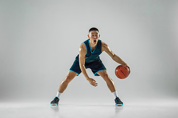 Image showing Young basketball player training isolated on white studio background