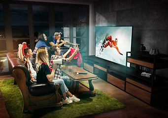 Image showing Group of friends watching TV, snowboarding sport games