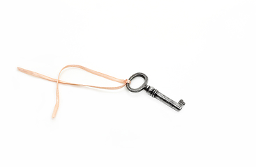 Image showing Vintage silver key with pink ribbon on white background