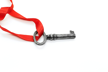 Image showing Vintage silver key with red ribbon on white background