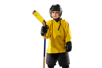 Image showing Little hockey player with the stick on ice court and white studio background