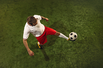 Image showing Top view of caucasian football or soccer player on green background of grass