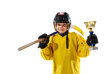 Image showing Little hockey player with the stick on ice court and white studio background