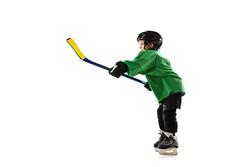 Image showing Little hockey player with the stick on ice court and white studio background