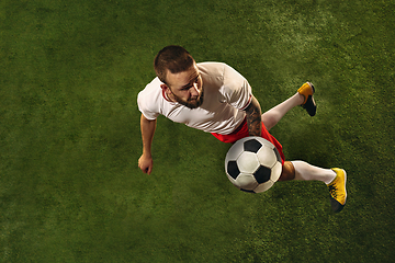 Image showing Top view of caucasian football or soccer player on green background of grass