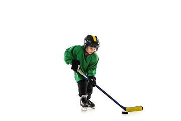 Image showing Little hockey player with the stick on ice court and white studio background