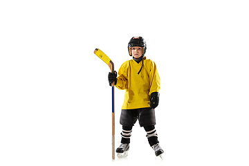 Image showing Little hockey player with the stick on ice court and white studio background