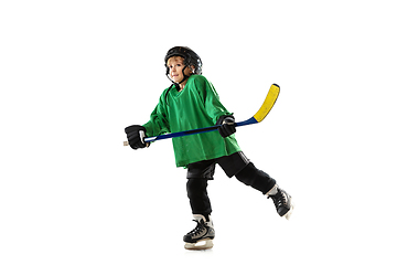 Image showing Little hockey player with the stick on ice court and white studio background