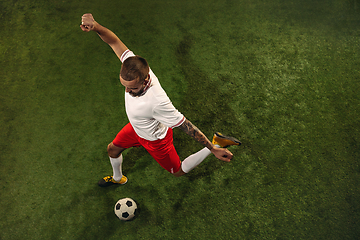 Image showing Top view of caucasian football or soccer player on green background of grass