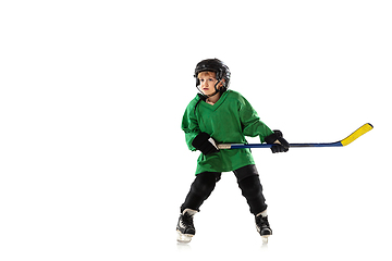 Image showing Little hockey player with the stick on ice court and white studio background