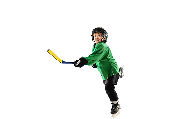 Image showing Little hockey player with the stick on ice court and white studio background