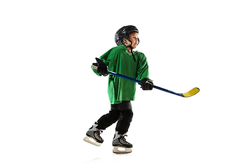 Image showing Little hockey player with the stick on ice court and white studio background