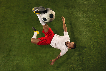 Image showing Top view of caucasian football or soccer player on green background of grass