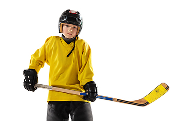 Image showing Little hockey player with the stick on ice court and white studio background