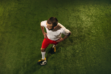 Image showing Top view of caucasian football or soccer player on green background of grass