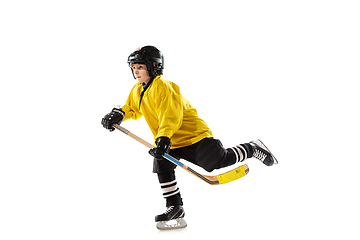 Image showing Little hockey player with the stick on ice court and white studio background
