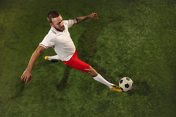 Image showing Top view of caucasian football or soccer player on green background of grass