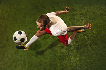 Image showing Top view of caucasian football or soccer player on green background of grass