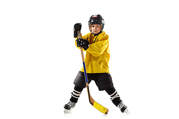 Image showing Little hockey player with the stick on ice court and white studio background