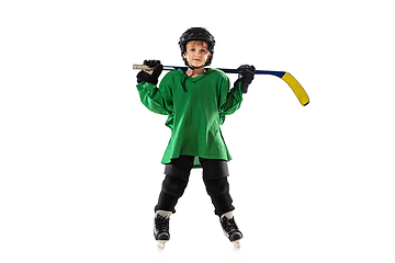 Image showing Little hockey player with the stick on ice court and white studio background