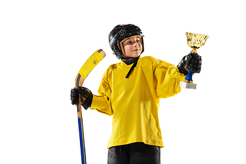 Image showing Little hockey player with the stick on ice court and white studio background