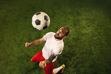 Image showing Top view of caucasian football or soccer player on green background of grass