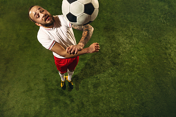 Image showing Top view of caucasian football or soccer player on green background of grass