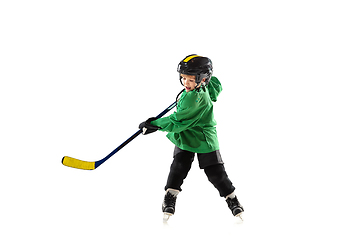 Image showing Little hockey player with the stick on ice court and white studio background