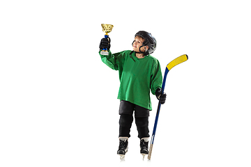 Image showing Little hockey player with the stick on ice court and white studio background