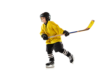 Image showing Little hockey player with the stick on ice court and white studio background