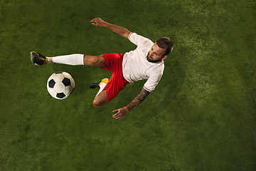 Image showing Top view of caucasian football or soccer player on green background of grass