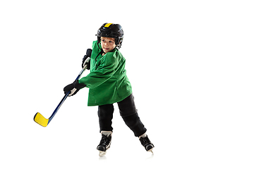 Image showing Little hockey player with the stick on ice court and white studio background