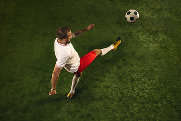 Image showing Top view of caucasian football or soccer player on green background of grass