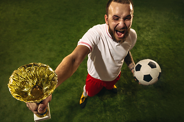 Image showing Top view of caucasian football or soccer player on green background of grass