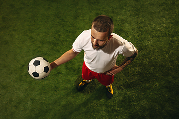 Image showing Top view of caucasian football or soccer player on green background of grass