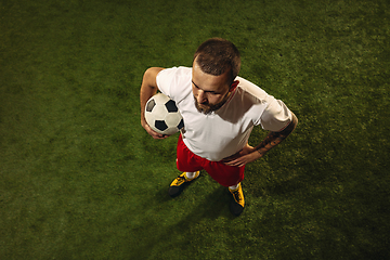 Image showing Top view of caucasian football or soccer player on green background of grass