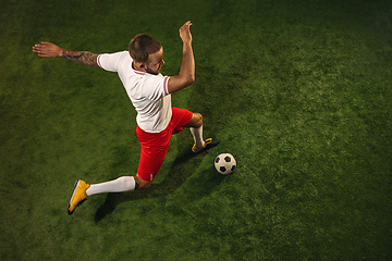 Image showing Top view of caucasian football or soccer player on green background of grass