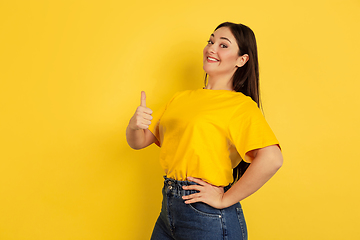 Image showing Caucasian woman\'s portrait isolated on yellow studio background