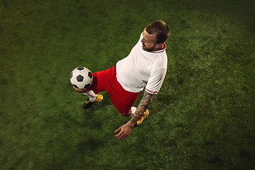 Image showing Top view of caucasian football or soccer player on green background of grass