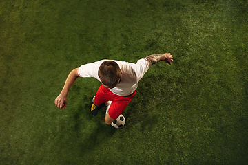 Image showing Top view of caucasian football or soccer player on green background of grass