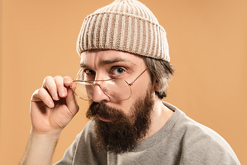 Image showing Portrait of Caucasian man in glasses and hat isolated on light background.