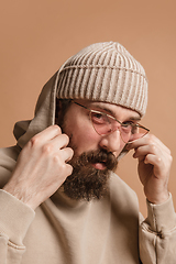 Image showing Portrait of Caucasian man in glasses and hat isolated on light background.