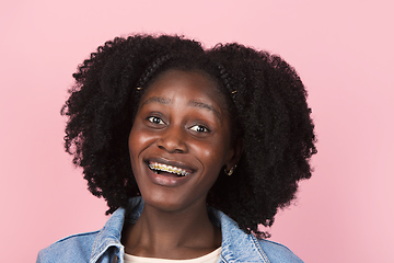 Image showing African-american woman portrait isolated on pink studio background with copyspace