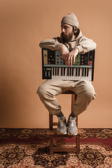 Image showing Full-length portrait of man, musician isolated on light yellow background.