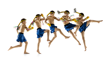 Image showing Little boy exercising thai boxing on white background. Fighter practicing, training in martial arts in action, motion. Evolution of movement, catching moment.