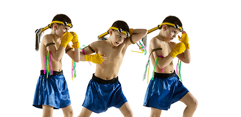 Image showing Little boy exercising thai boxing on white background. Fighter practicing, training in martial arts in action, motion. Evolution of movement, catching moment.