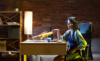 Image showing Young Caucasian woman during online cooking lesson through laptop.