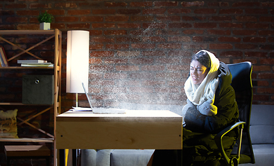 Image showing Young woman in oversized black puffy jacket meeting winter on virtual video call