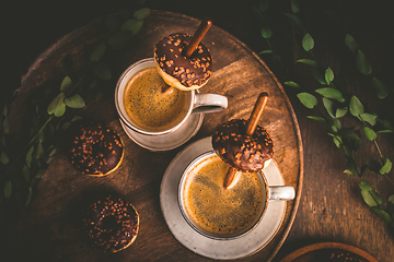 Image showing Two cups of Caffe Americano with small chocolate donuts