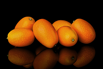 Image showing Heap of ripe kumquats on black background